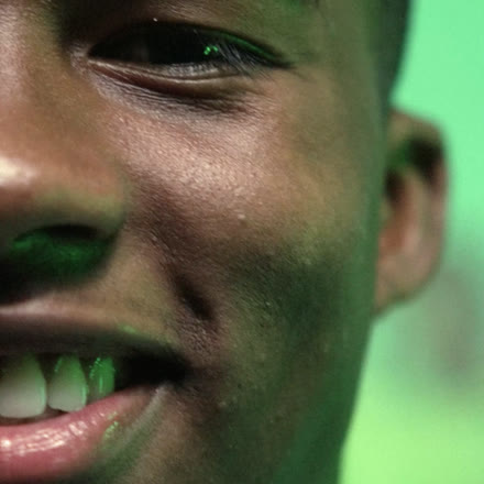 Close de Endrick sorrindo sob a luz verde nos bastidores