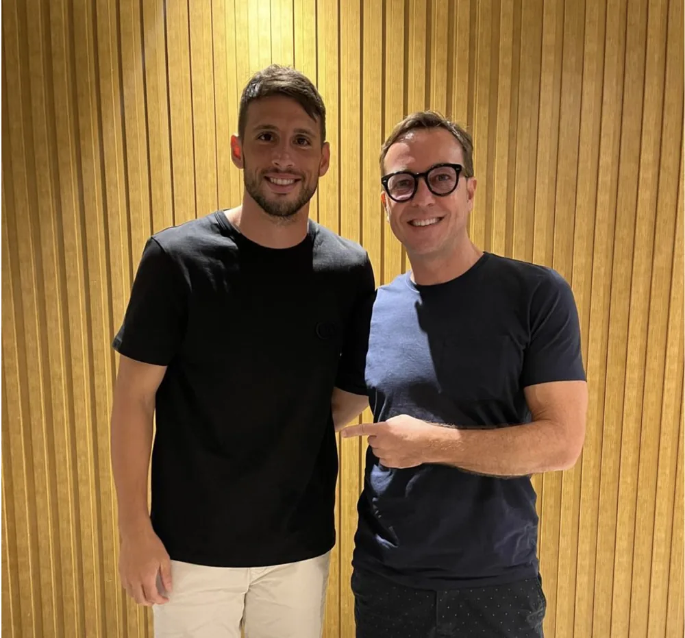 Calleri and Fabio Brancatelli in front of a wooden wall